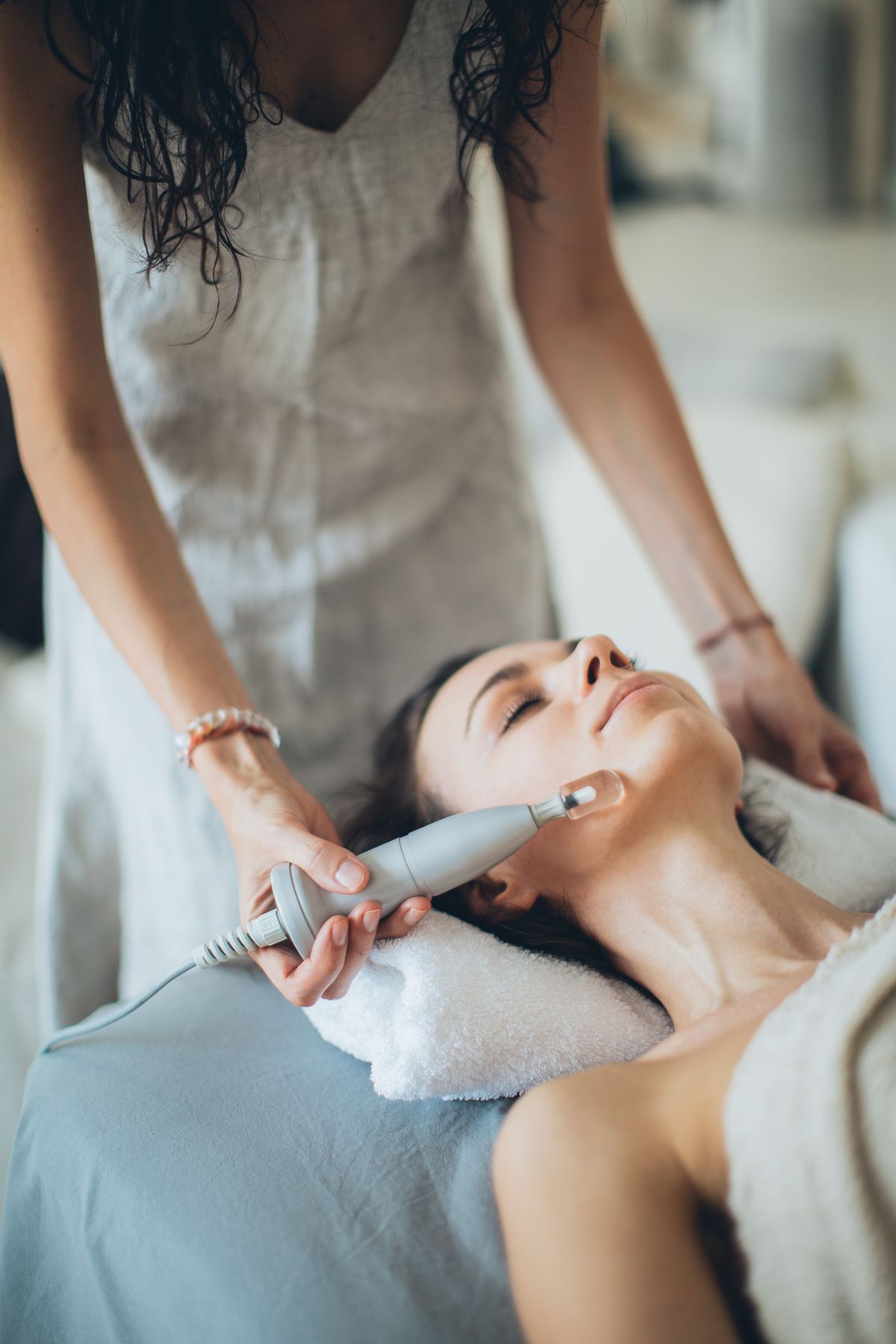A client relaxing during a facial device treatment at an upscale spa