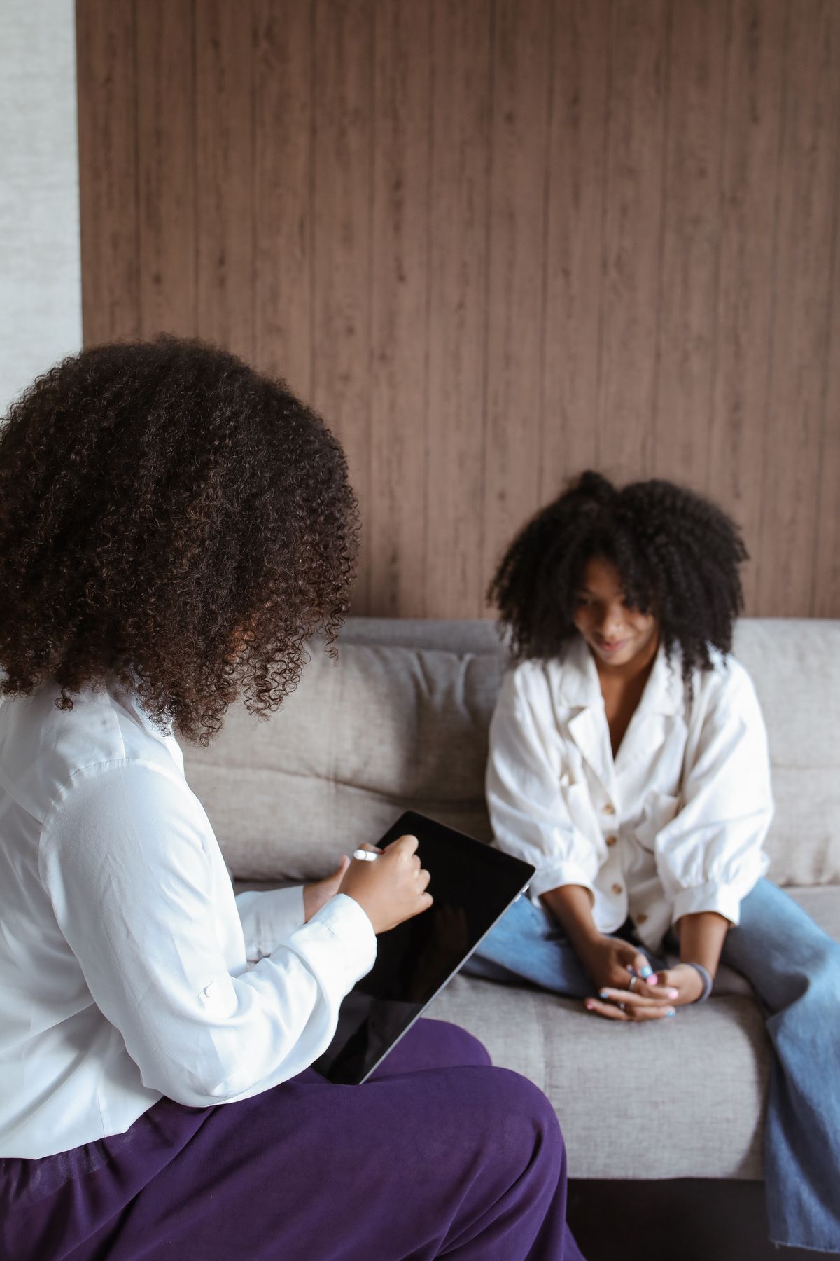 A therapist in conversation with a client in a warm consulting room