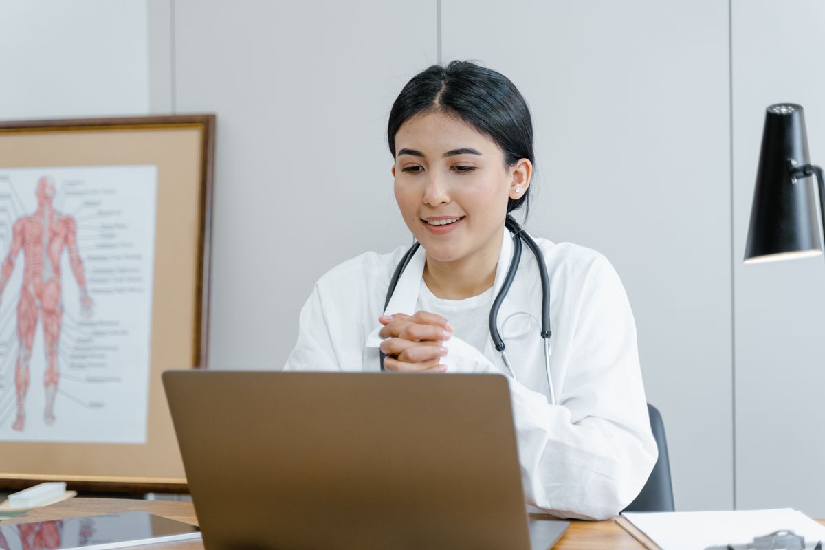 A clinician holding a video consultation from a modern workspace