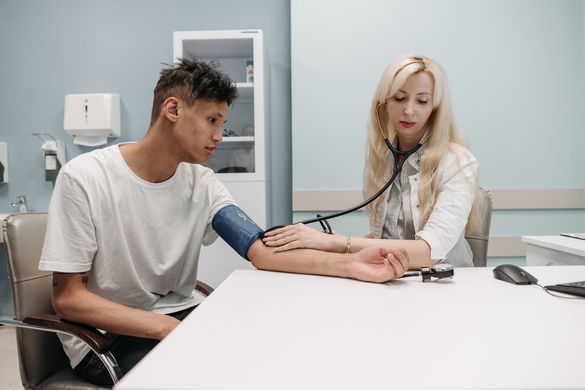 A clinician checking a walk-in patient's blood pressure at an urgent care center